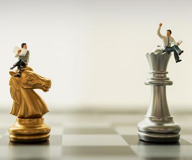 The graphic shows two interim managers sitting on chess pieces.