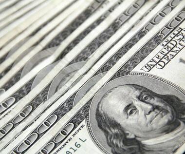 Interim financial management: The picture shows several 100-dollar bills that are slightly offset.
