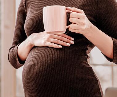 Parental leave replacement: The picture shows a pregnant woman placing a coffee cup on her stomach.