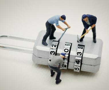 Change management: The picture shows figures trying to pick a combination lock.