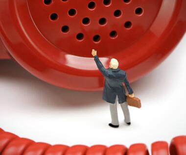 Feedback culture for agile organizational development: The picture shows a figure in front of a red telephone receiver.