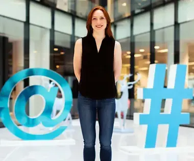 Interim Management Marketing: Das Bild zeigt eine Frau zwischen einem @-Zeichen und einem #-Zeichen