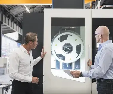 Interim Management Operations: The picture shows two Operations Managers in front of a production machine.