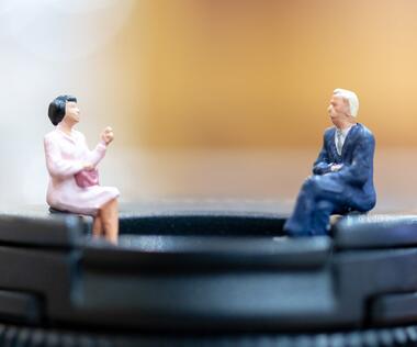 Employee survey: The picture shows two figures having a conversation.