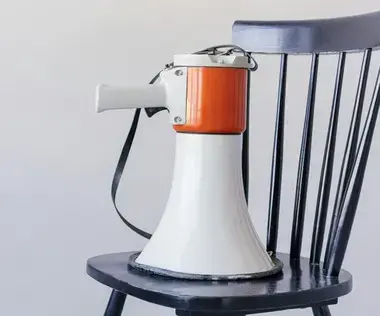 Interim Management Corporate Communications: The picture shows a megaphone on a chair.