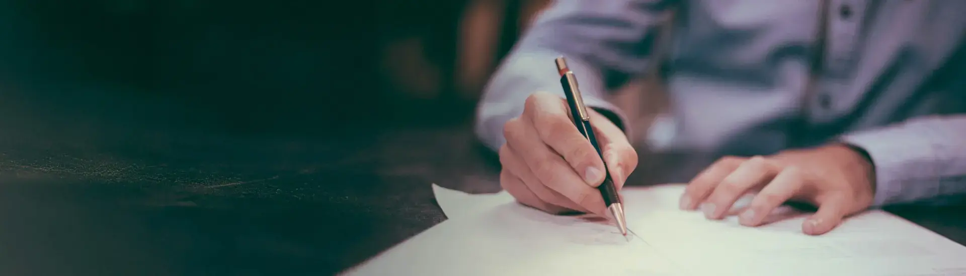 Interim accountant: The picture shows an interim accountant writing on a sheet of paper.