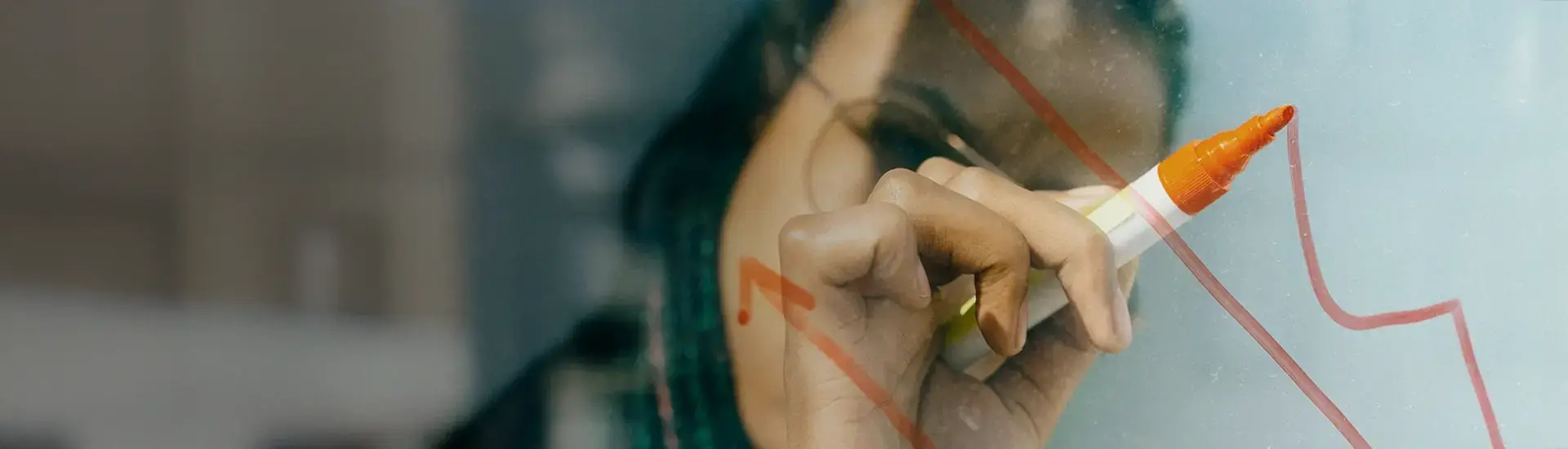 Interim Management Controlling: The picture shows a woman drawing a diagram on a transparent flipboard.