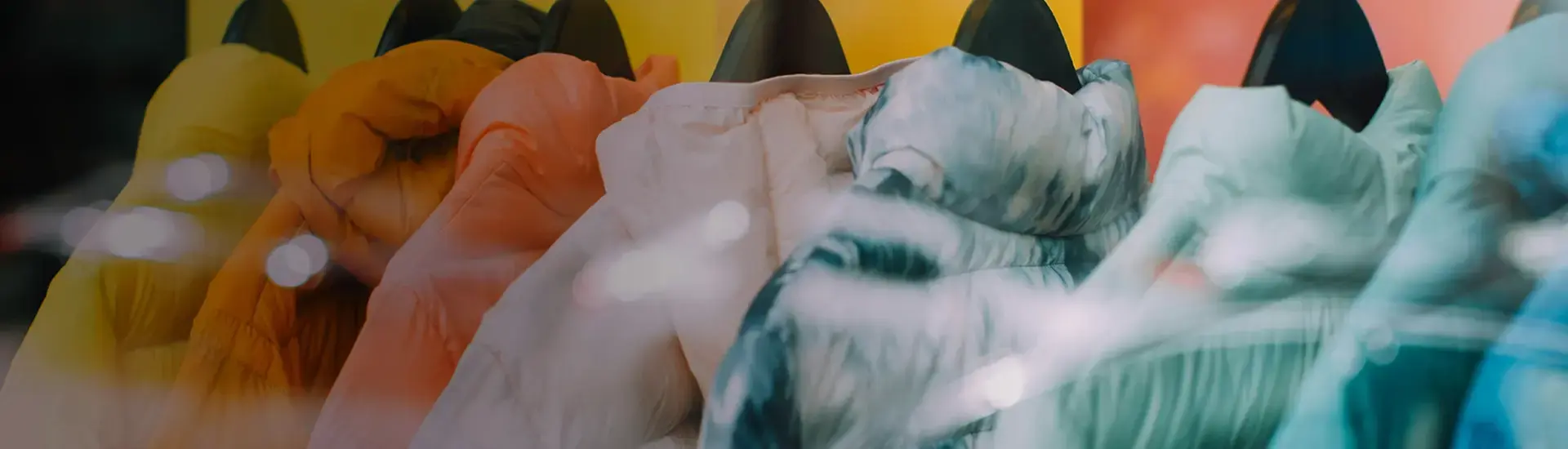 Interim Management Consumer Goods & FMCG: The picture shows colored jackets on hangers.