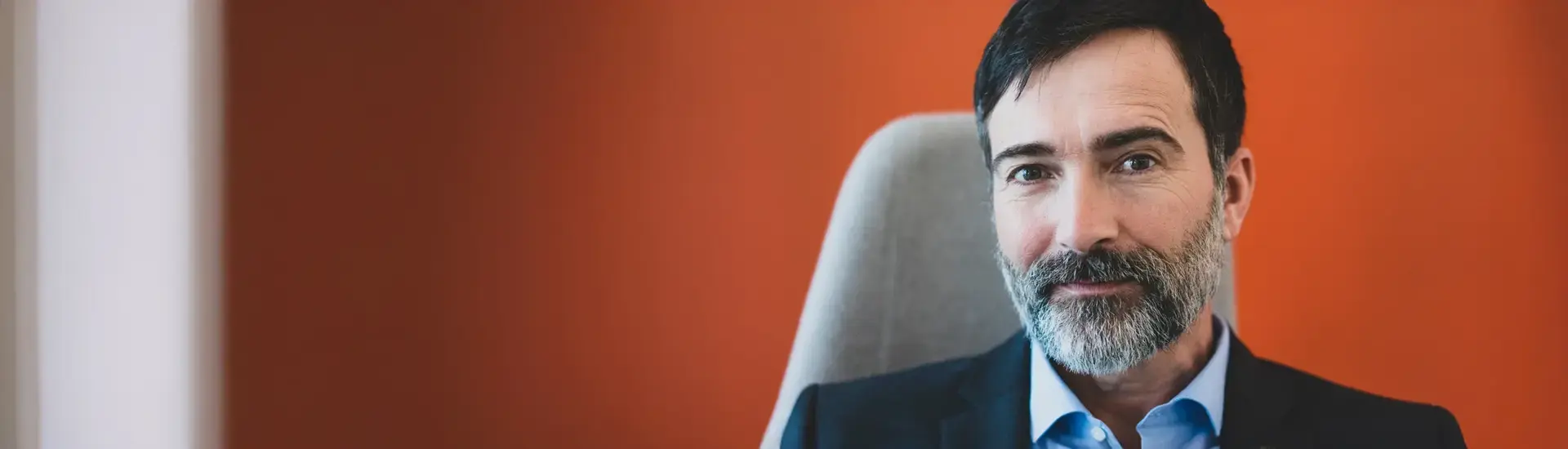 Interim CEO: The picture shows an interim CEO in front of a red wall.