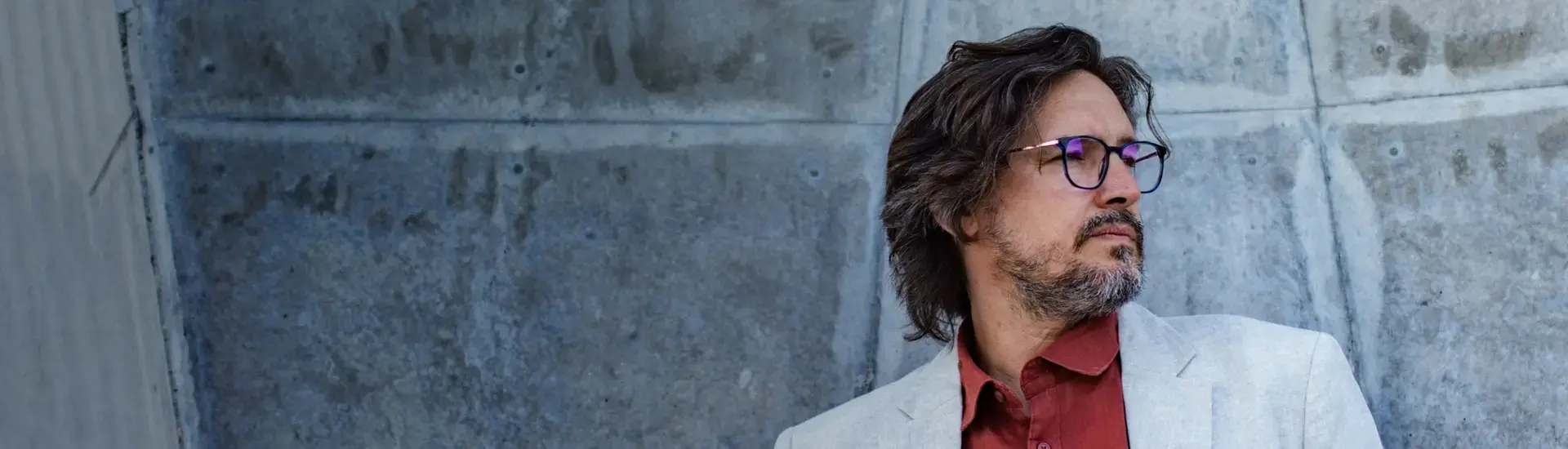 Interim CIO: The picture shows a thoughtful interim CIO in front of a concrete wall.