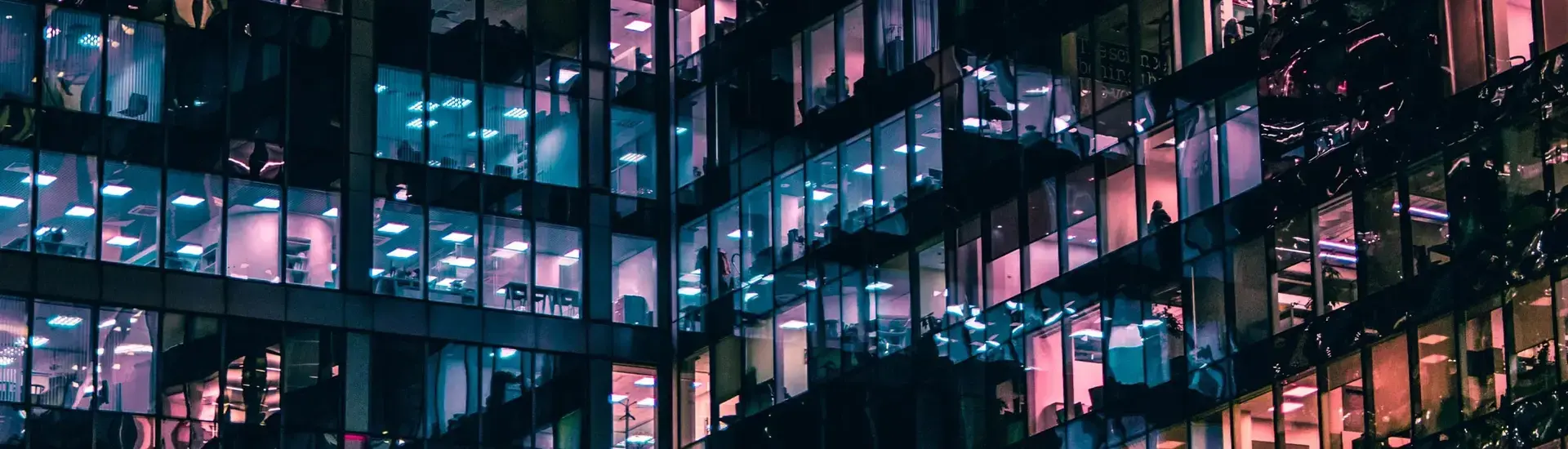 Interim Management HR: The picture shows an office building with colorfully illuminated windows.