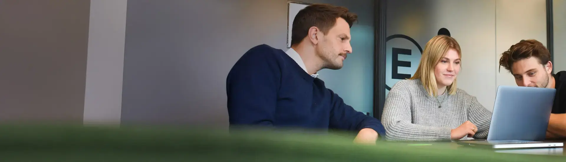 Interim Management Internal Communication: The picture shows three communication managers working on a laptop.