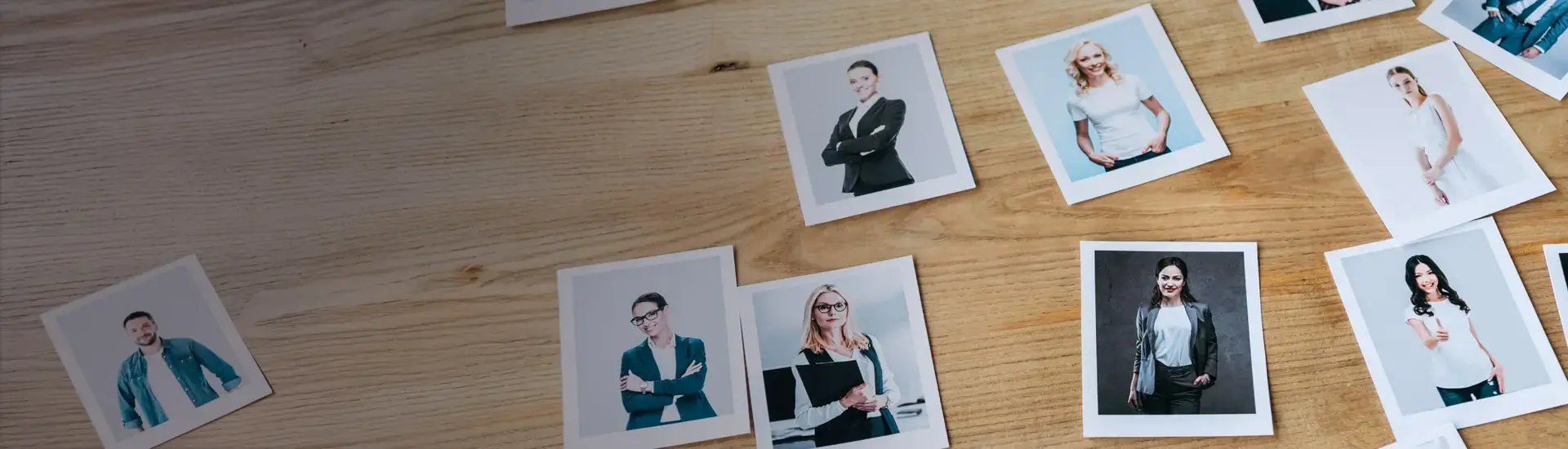 Interim Management Personnel Development and Personnel Training: The picture shows Polaroid pictures with people on a wooden table.
