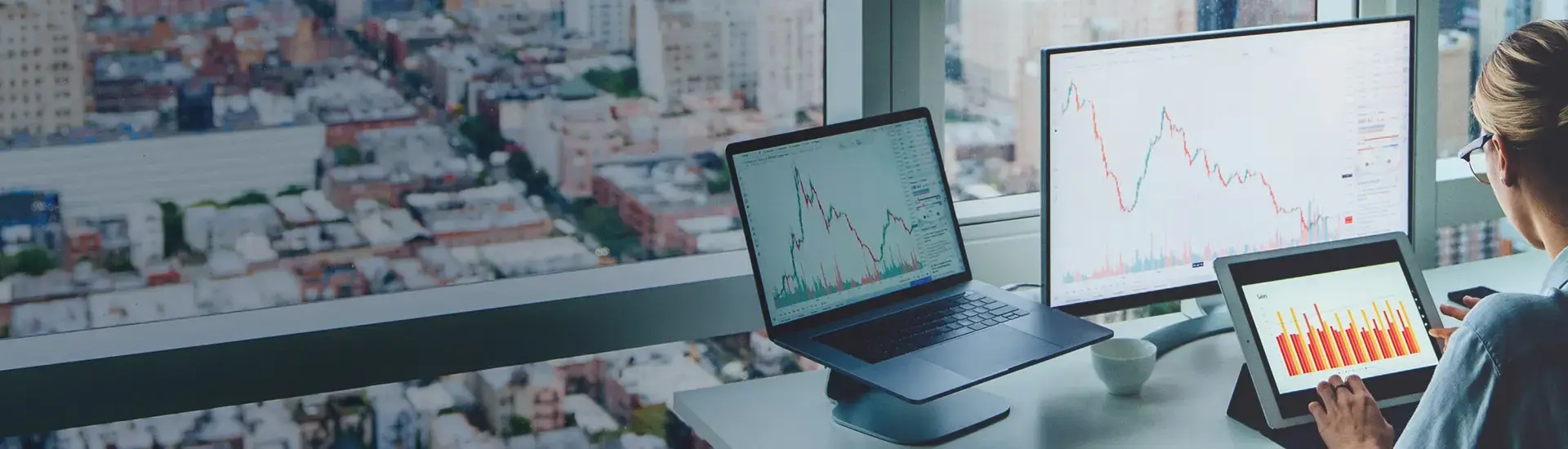 Interim Treasury Management: The picture shows a treasury manager looking at charts on several screens.