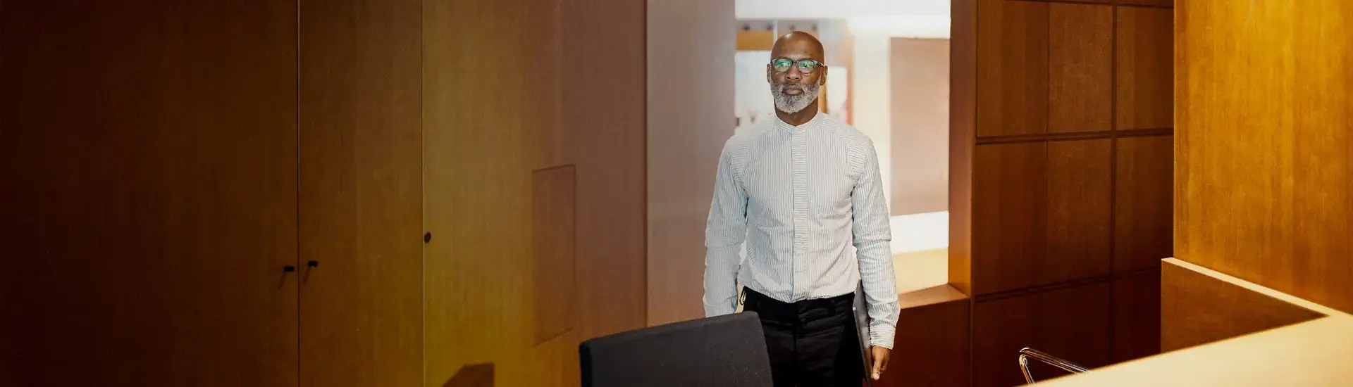 The picture shows a manager entering a meeting room.