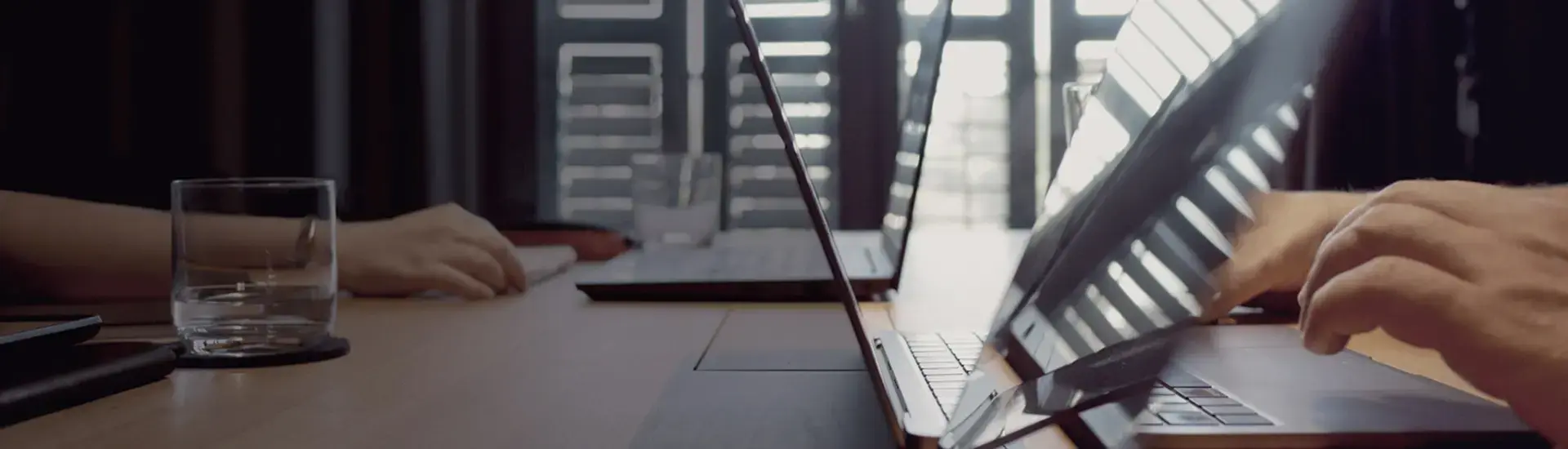 The picture shows a communications manager writing on his laptop.