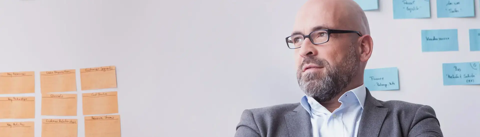 Interim Portfoliomanagement: Das Bild zeigt einen Portfoliomanager vor einer weißen Wand mit farbigen Post-its.
