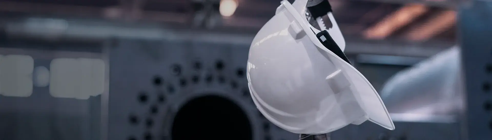 Production relocation: The picture shows a white safety helmet in a factory environment.