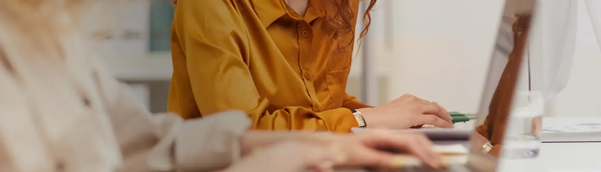 Interim Payroll Manager: The picture shows the hands of a payroll specialist working on a laptop.