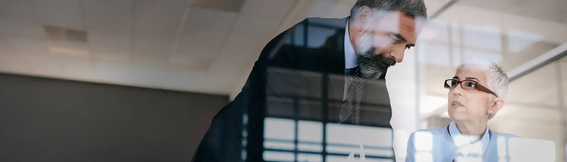 Interim Head of Finance: Das Bild zeigte einen Leiter Finanzen, der einer Mitarbeiterin etwas erklärt.