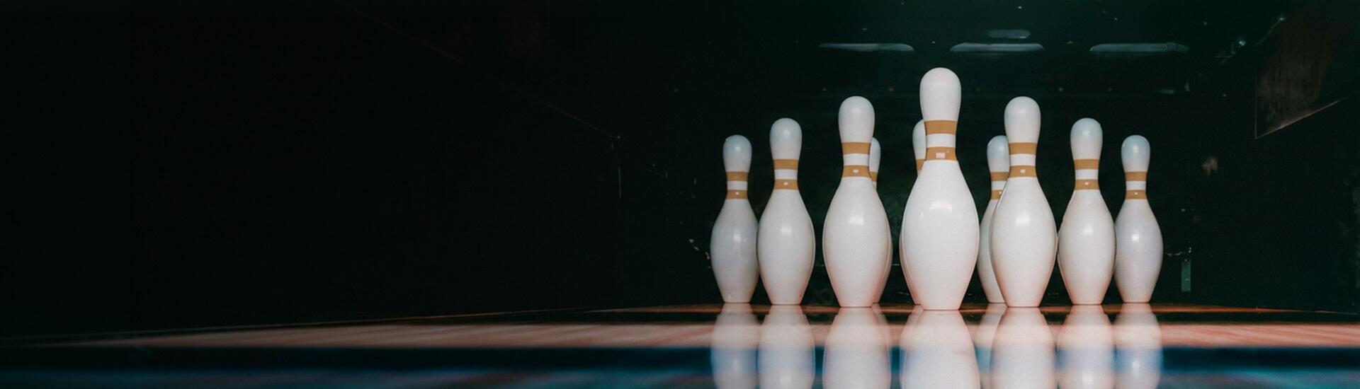 Manager Ranking: Das Bild zeigt weiße Bowling-Pins auf einer blauen Bowling-Bahn.