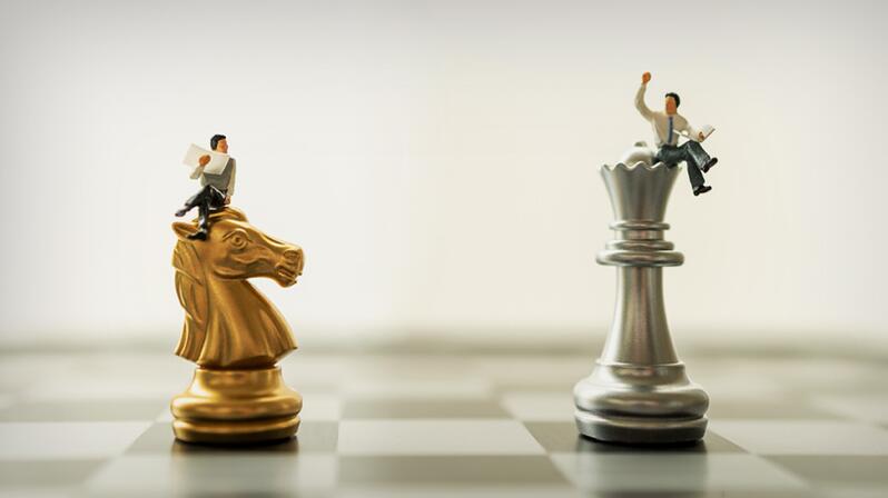The graphic shows two interim managers sitting on chess pieces.