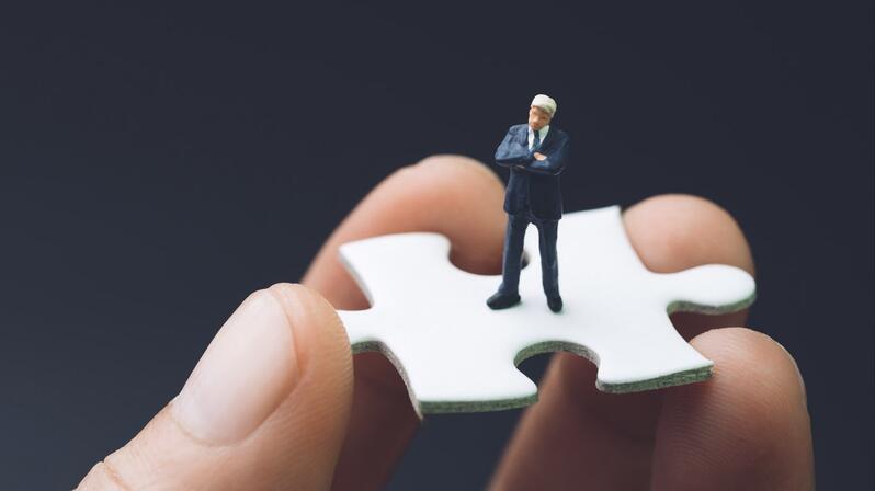 Interim manager on puzzle piece that symbolizes his accuracy of fit.