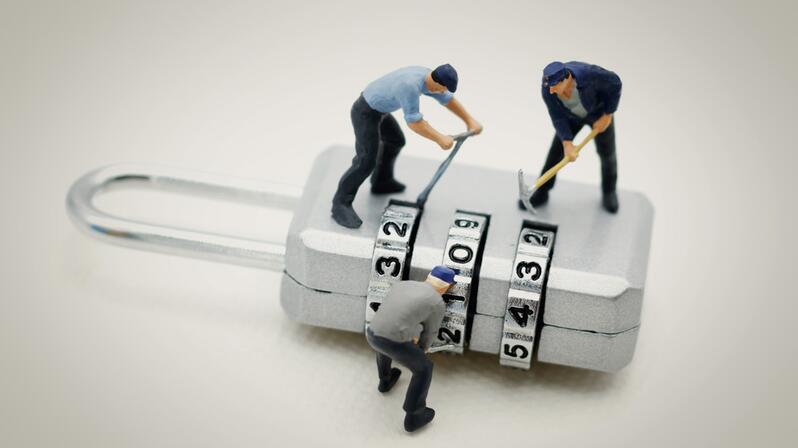 Change management: The picture shows figures trying to pick a combination lock.