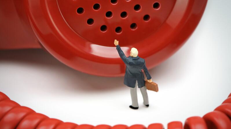 Feedback culture for agile organizational development: The picture shows a figure in front of a red telephone receiver.