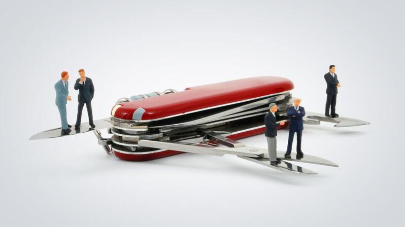 HR Shared Service Center: The picture shows several figures standing around a Swiss army knife.