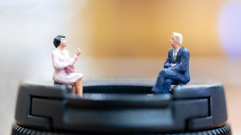 Employee survey: The picture shows two figures having a conversation.