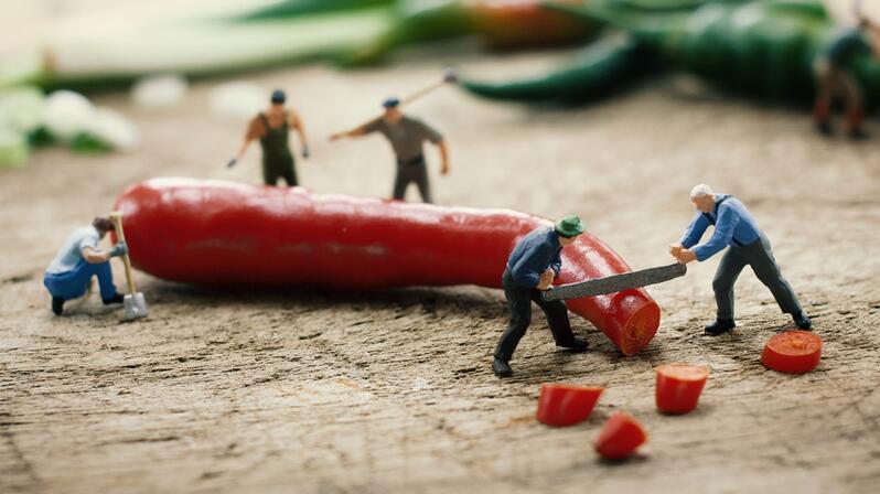 Creating security of supply in supply chains: The picture shows figures sawing up a chili.