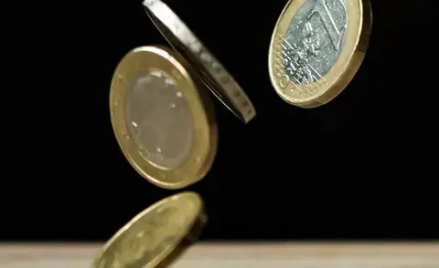 Solving financial challenges with interim management: The picture shows coins falling onto a table.
