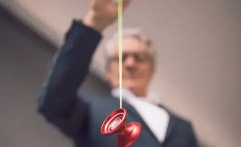 Interim Management Corporate management: The picture shows a businessman with a yoyo