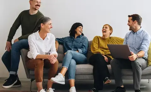 Overcoming HR challenges with interim management: The picture shows employees on a sofa.