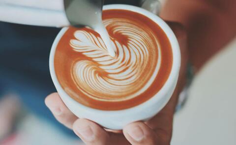 Interim Management: The picture shows how a barista skillfully prepares a cappuccino.