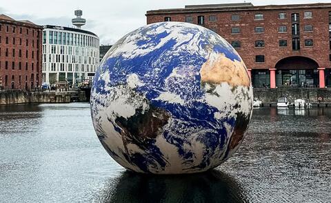 Interim Management: The picture shows a globe floating on a river.